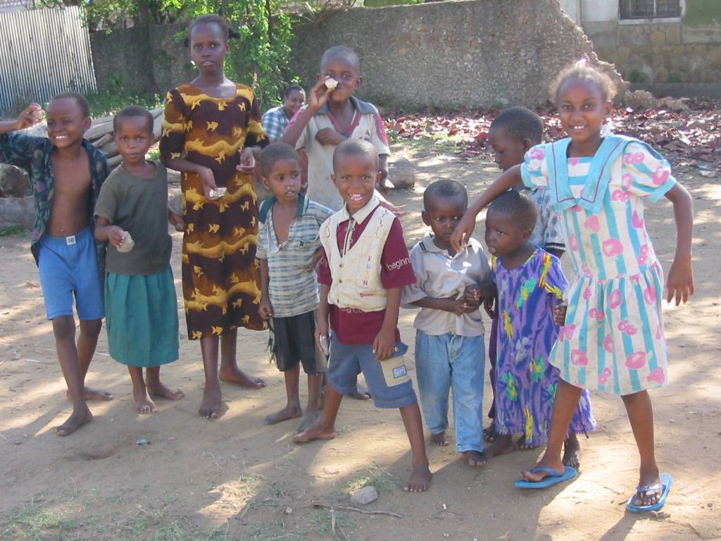 Satu Bianchi interagisce con un gruppo di bambini sorridenti nel villaggio di Mishomoroni, mostrando la sua empatia e capacità di creare legami.