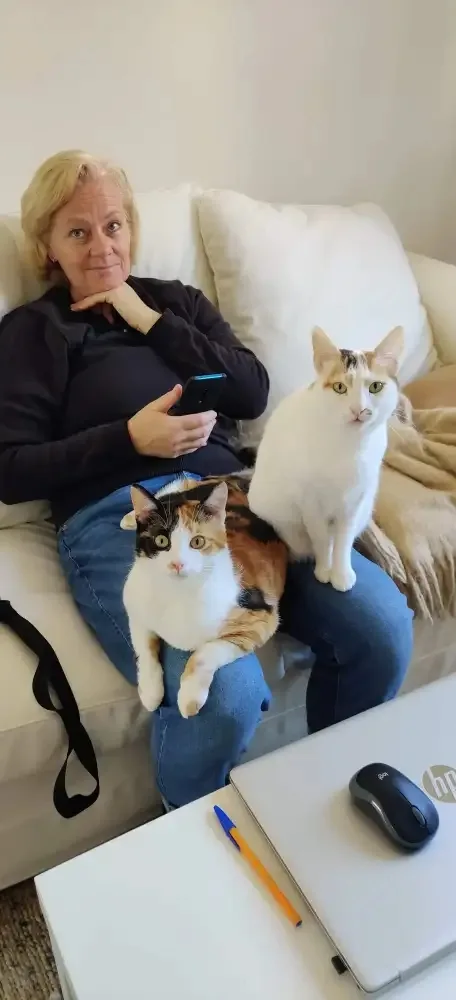 Satu Bianchi a casa a Rimini con le sue gatte Luna e Sole, un'immagine che comunica stabilità, affidabilità e il suo attuale radicamento sul territorio.