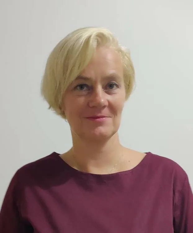 Primo piano di Satu Bianchi, un'espressione calma e competente ideale per l'accoglienza clienti e la gestione del punto vendita.