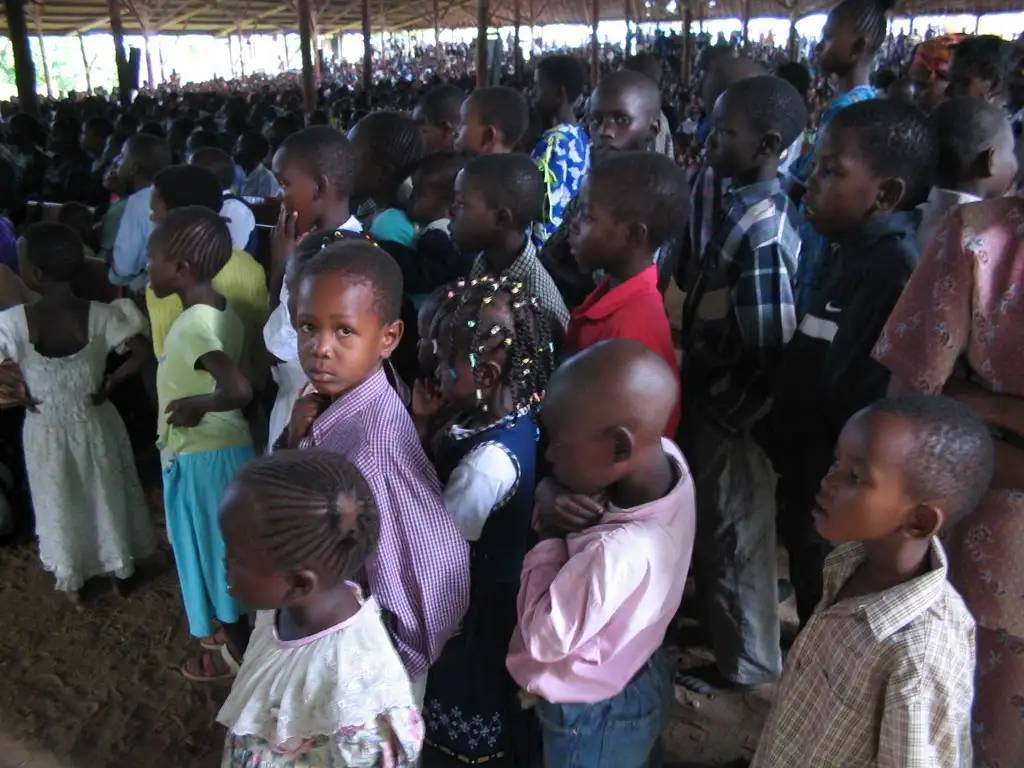 Satu Bianchi in mezzo a una folla di bambini in Kenya, a suo agio e in controllo, dimostrando la sua abilità nel gestire grandi gruppi con calma.