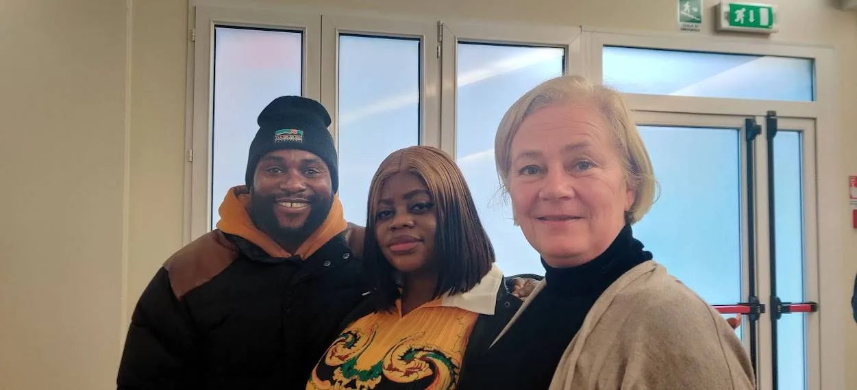 Satu Bianchi a Rimini mentre aiuta una coppia, dimostrando che il suo impegno nel supporto interculturale continua attivamente anche in Italia.